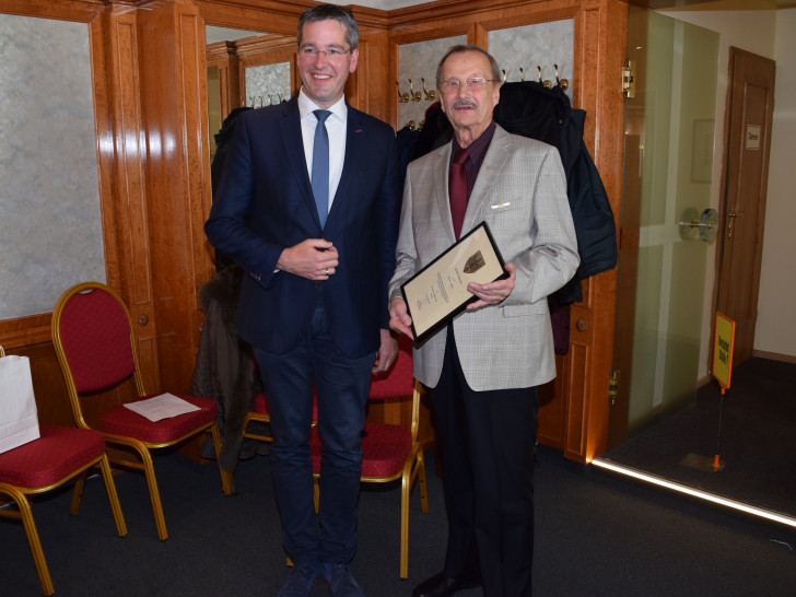 Oberbürgermeister Dr. Oliver Junk übergibt Eckehardt Hubitschka die Urkunde im Rahmen der Verleihung der Ehrennadel der Stadt Goslar. Foto: Stadt Goslar