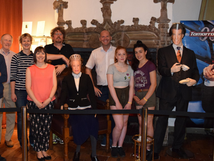 Begeistert von der James-Bond-Ausstellung posieren die drei Schüler mit Bürgermeister Mahnkopf (Mitte) und ihren begleitenden Lehrkräften neben der Queen und Pierce Brosnan. Fotos: Stadt Goslar 