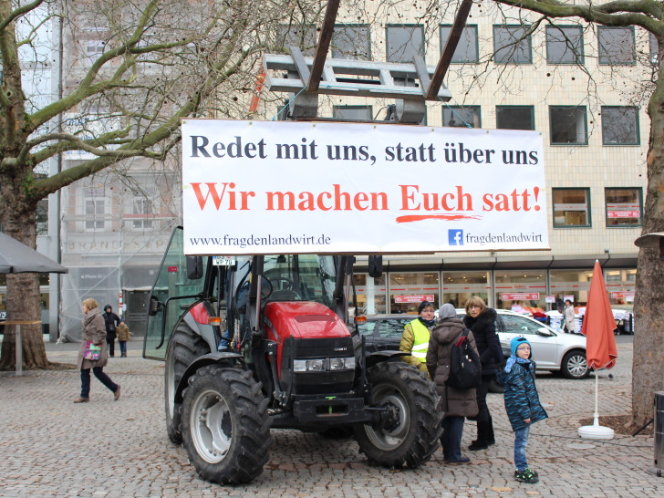 „Redet mit uns, statt über uns – Wir machen satt“ steht auf dem Plakat, das die Landwirte an einen Trecker mitten auf dem Kohlmarkt hangen. Fotos: Jan Borner
