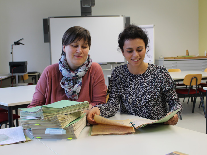 Steffi Crain (links) und Anita Placenti-Grau (rechts) vom Institut für Zeitgeschichte und Stadtpräsentation mit der Archivalie des Monats. Foto: Christoph Böttcher.