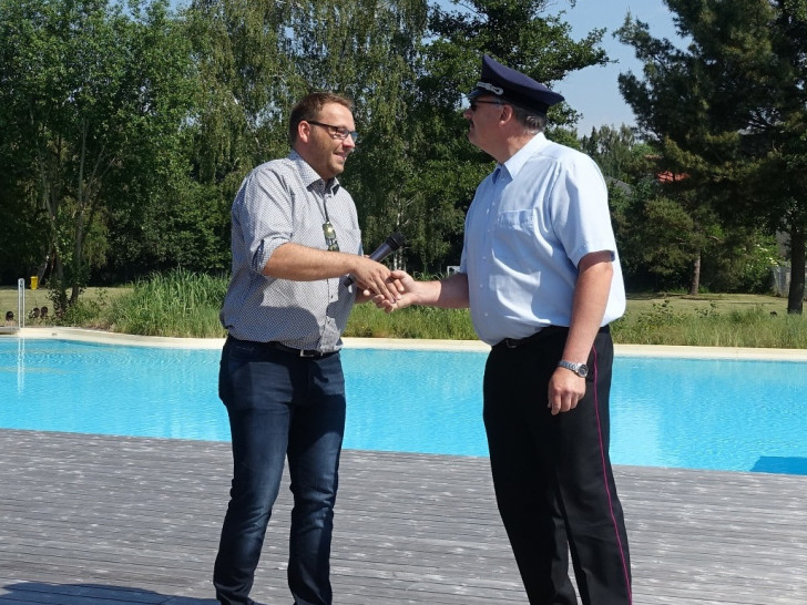 Samtgemeindebürgermeister Gero Janze übergibt die Ausweise zur kostenlosen Nutzung des Bades an Gemeindebrandmeister Maik Wermuth. Foto:  Samtgemeinde Grasleben