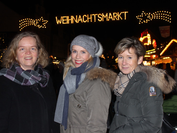Vera Steiner, Corinna Düe und Kerstin Hecker vor dem beleuchteten Weihnachtsmarkt. Foto: Anke Donner 