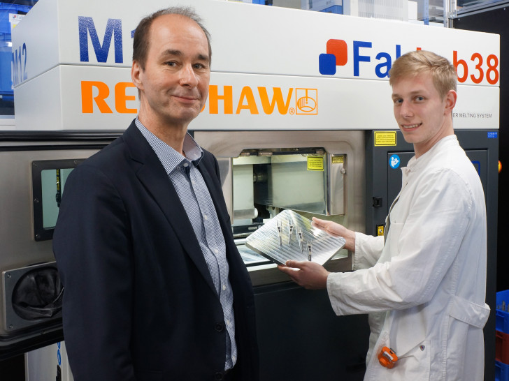 Prof. Dr. Christoph Haas und Student Fabian Sprenger begutachten Bauteile aus dem industriellen 3D Drucker. Foto: Ostfalia