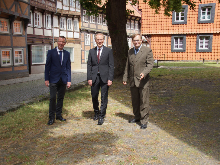 Die beiden Kirchenvorsteher Jörg Meyer (links) und Dr. Thomas Dahms (rechts) gehen gemeinsam mit Pfarrer Olaf Schäper (Mitte) auf dem „Steinweg“, dem ältesten dokumentierten und erhaltenen Pflasterweg der Stadt Hornburg um die Marienkirche. Foto: Gemeinde Hornburg