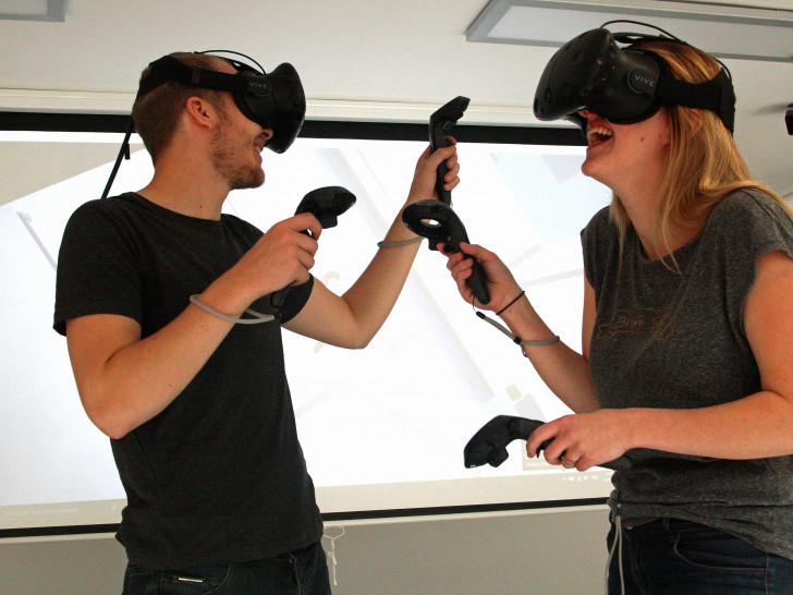 Irina Shiyanov und Max Bäßmann vom Team der VirtuaLounge erkunden mit Hilfe von Virtual-Reality-Brillen ein Raumschiff. Foto: Braunschweig Zukunft GmbH / Fabian Kappel)