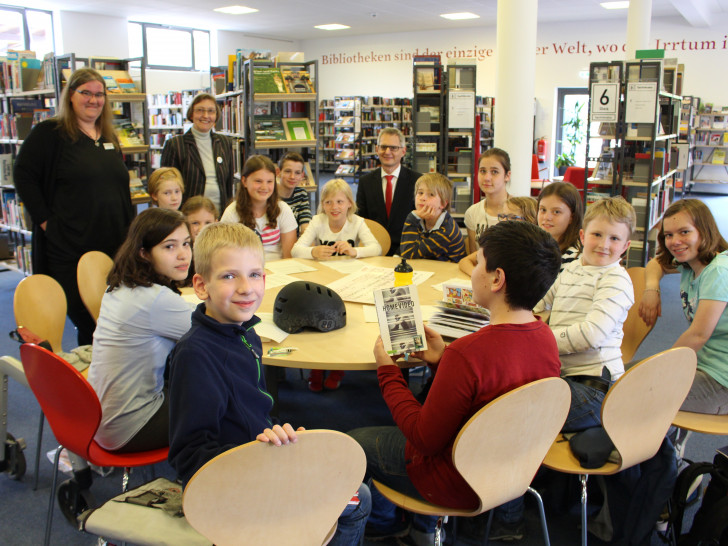 Von links: Lese-Club-Leiterin Meike Buthmann, Ille Schneider vom Freundeskreis der Stadtbücherei und die Kinder freuen sich über die Spende der Braunschweigischen Sparkassenstiftung vertreten durch Beiratsmitglied Meik Rahmsdorf. Foto: Max Förster