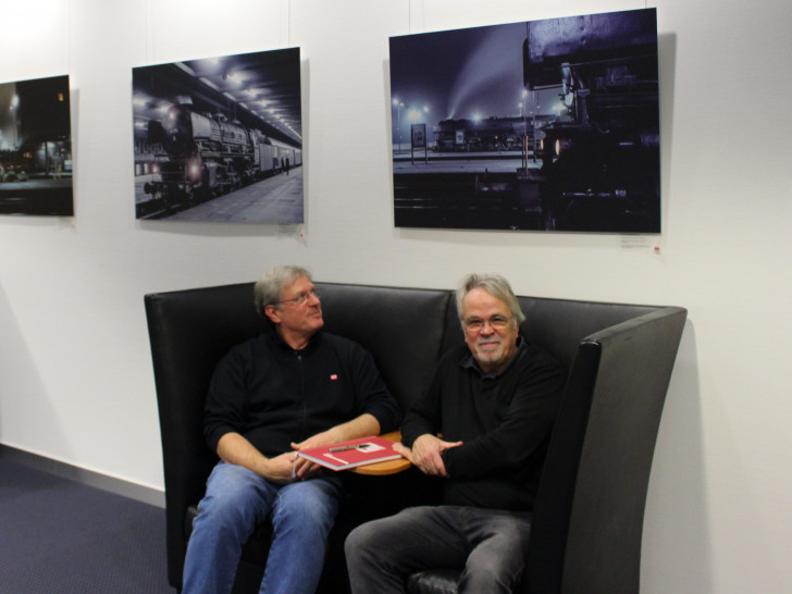 Christian Ernst (links) und Hans-Georg Ahrens betrachten die Eisenbahnfotos. Foto: Frederick Becker 