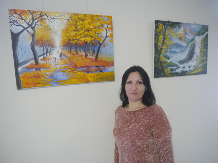 Die Gifhorner Künstlerin Olga Nikiforyak mit zwei Bildern ihrer Ausstellung. Foto: Helios Klinikum Gifhorn