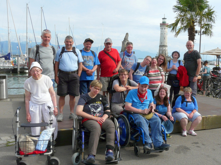 Eine Reisegruppe posiert am Bodensee. Im Hintergrund ist der
Leuchtturm von Lindau. Foto: Privat