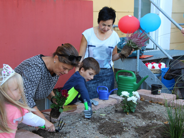 Nach der Begrüßung wurde das frisch angelegte Hochbeet in einer gemeinsamen Aktion bepflanzt. Foto: NEULAND Wohnungsgesellschaft mbH 