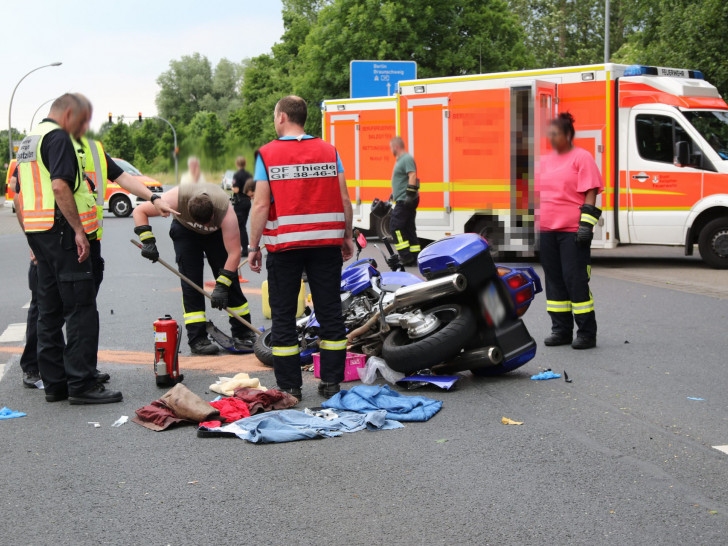 Während der verletzte Fahrer im Rettungswagen liegt, räumt die Feuerwehr bereits die Straße auf. Foto: Rudolf Karliczek