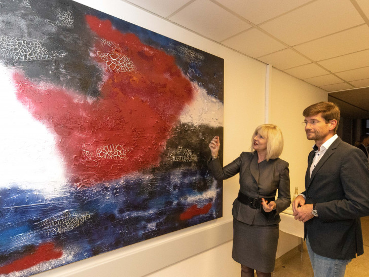 Die Künstlerin Marion Dollenberg präsentiert Lutz Blume eines ihrer Bilder. Foto: Rudolf Karliczek