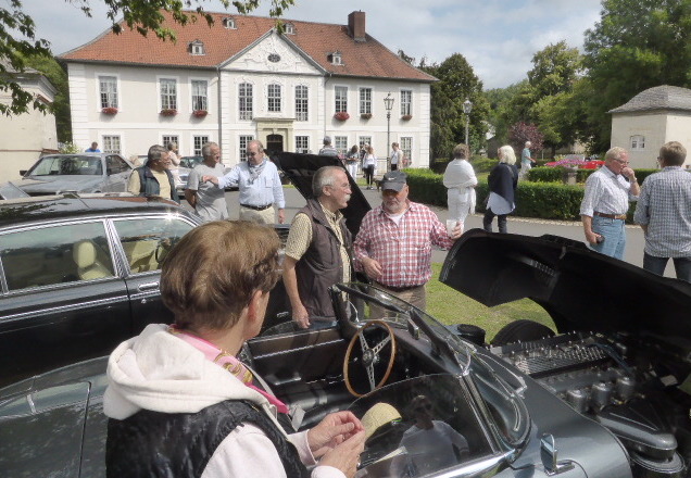 Besucher und Fahrtteilnehmer an den historischen Fahrzeugen vor dem Schloßpotal. Foto: Seniorenbetreuung Schloß Schliestedt