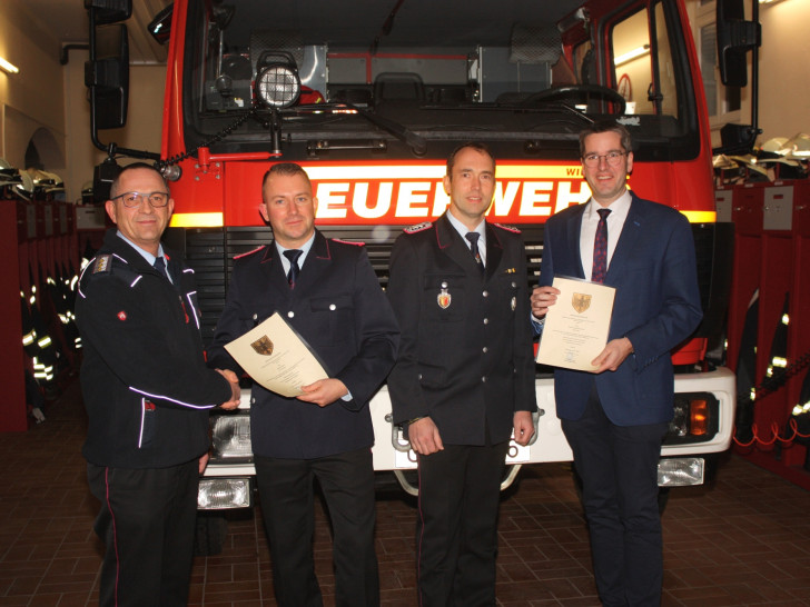 Oberbürgermeister Dr. Oliver Junk (rechts) und Christian Hellmeier gratulieren Ortsbrandmeister Kai Wegener und seinem Stellvertreter Ingo Politz (von links).