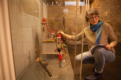 Doris Schulz-Wahle beim Aufbau der Ausstellung "Kinderträume aus buntem Holz". Foto: Stadtmuseum Schloss Wolfsburg/Peter Riewaldt