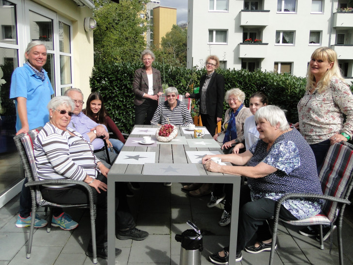 Die Teilnehmer der Demenzgruppe freuen sich mit Manuela Patricny, Sozialarbeiterin und Pädagogin im Paritätischen Wohl- fahrtsverband, Praktikantin Laura Barth, Geschäftsführerin Christine Köhler-Riebau, Sparkassensprecherin Alexa von der Brelje, Auszubildende Anastasia Mantarli und Pflegerin Gabriele Steckhahn über die neuen Gartenmöbel. Foto: Sparkasse Gifhorn-Wolfsburg