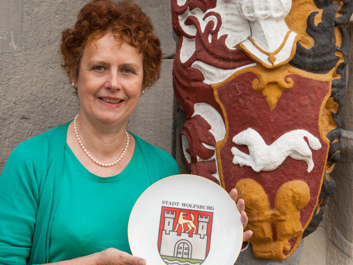 Dr. Karin Luys präsentiert das Wolfsburger Stadtwappen vor dem Schloss Wolfsburg. Foto: Stadtmuseum Wolfsburg