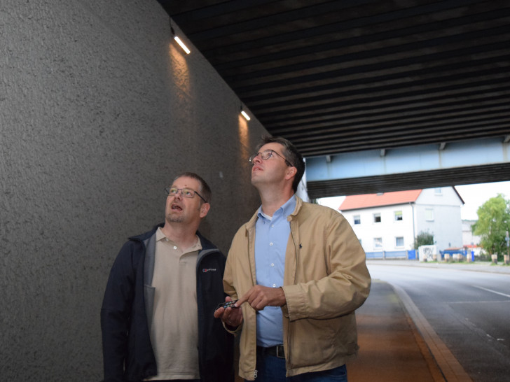 Dr. Oliver Junk (rechts) und Mathias Brand testen die Fernbedienung für die neuen LEDLeuchten
von HarzEnergie in der Unterführung. Foto: Stadt Goslar