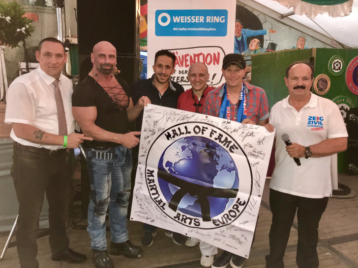 Zusammen mit seinen Kollegen Peter Sander und Thomas Stolkmann übergab er Koschig einen Scheck in Höhe von 700 Euro sowie ein Banner mit Unterschriften von Karateweltmeistern aus der ganzen Welt für die Goslarer Zivilcouragekampagne. Foto: WEISSER RING