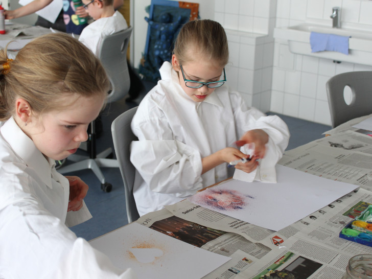 Die beiden Emilys zeigen ihre Kreativität bei der Farbspritztechnik mit einer Zahnbürste. Foto: Max Förster