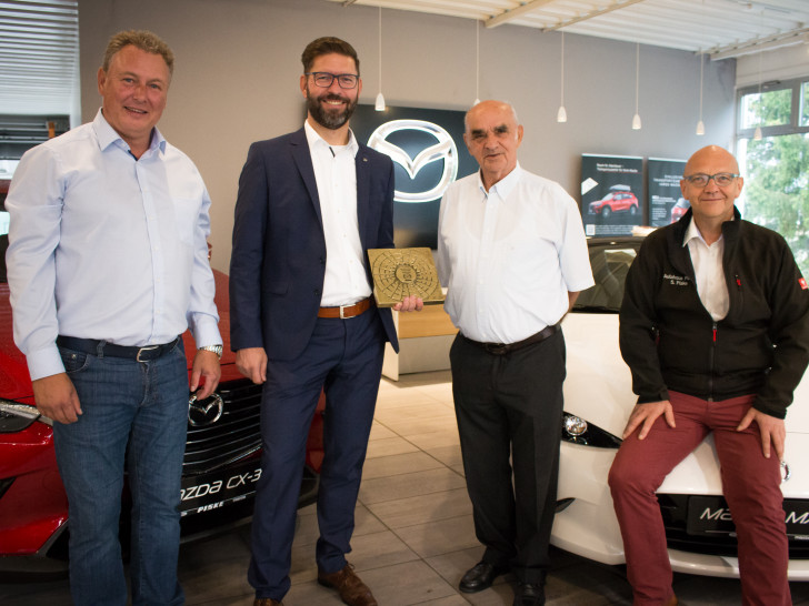 Geschäftsführer Stefan Piske (rechts), Inhaber Hans-Georg Piske sowie Verkaufsleiter Frank Neuendorff (links) freuen sich über die Auszeichnung zum Jubiläum durch Mazda Distriktmanager Heiner Borde (2. v.l.). Foto: Werner Heise