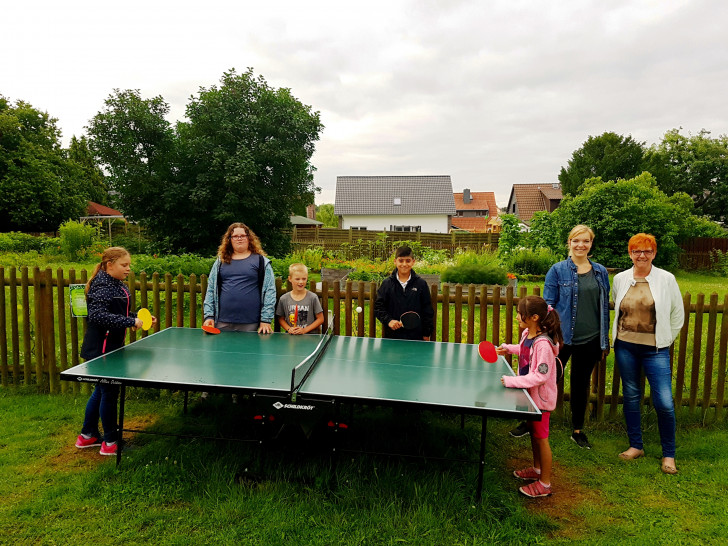 Die Ulmen-Kinder Sarah (von links), Jennifer, Jonas, Orhan, Shina sowie Susanne Pensler und Katrin Lettow freuen sich über die Tischtennisplatte im Gemeinschaftsgarten. Foto: Ulme