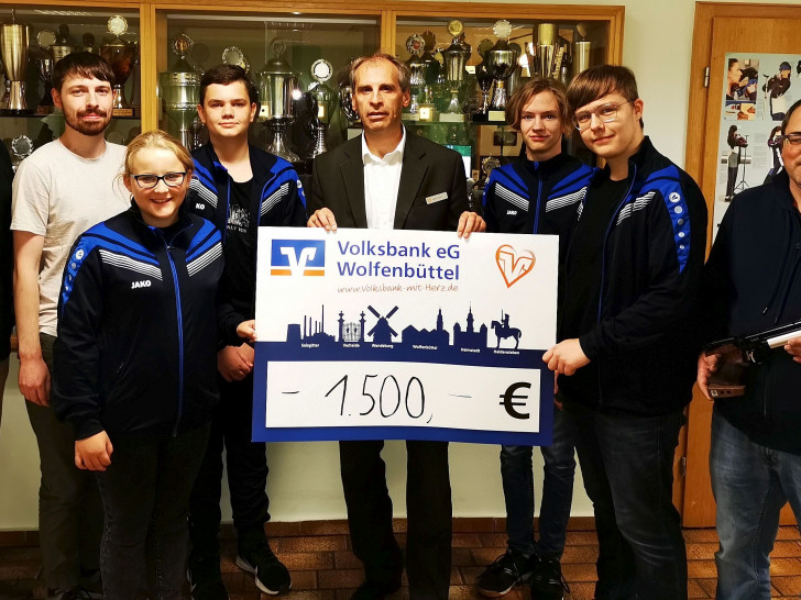 Marco Lorenz, Volksbank eG Wolfenbüttel mit dem Check, Sportleiter Martin Tomicki mit der fünfschüssigen Luftpistole, der Jugendleiter Birk Dietrich, Vorsitzender Matthias Lorenz und Mitglieder der Jugendabteilung. Foto: SBr. Süpplingen von 1952 e.V. 