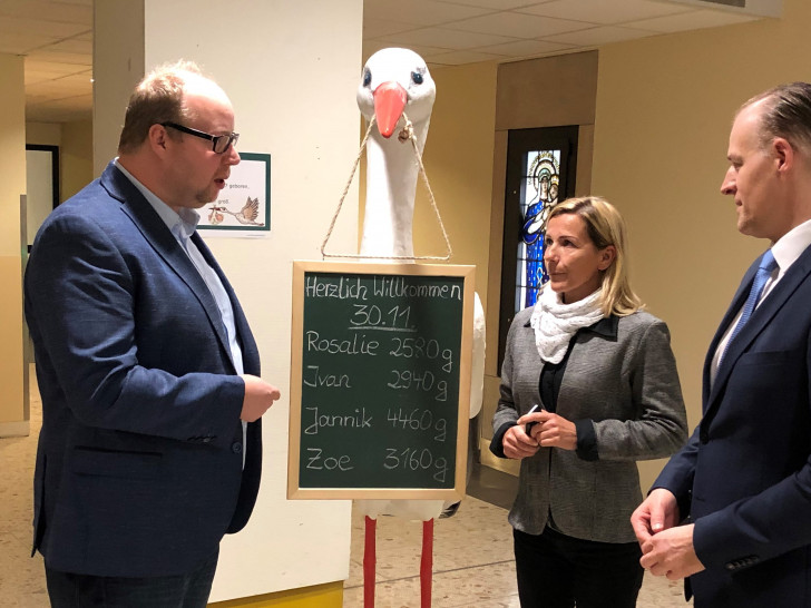 Jörn Domeier, MdL; der Storch mit der Geburtstafel, Aline Preisbisch und Matthias Hahn. Foto: Abgeordnetenbüro Jörn Domeier