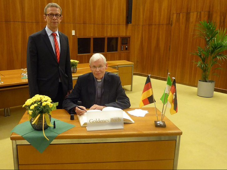 Weihbischof Dr. Nikolaus Schwerdtfeger trägt sich ins Goldene Buch der Stadt Wolfsburg ein. Foto: Stadt Wolfsburg