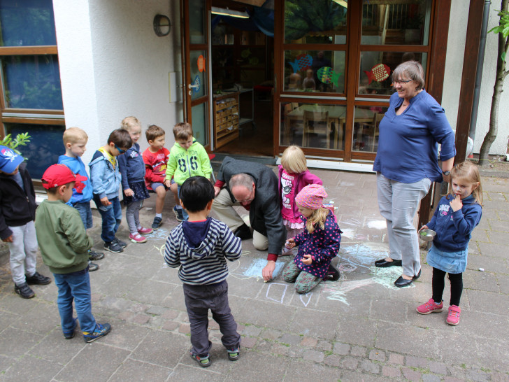 Pastor Friedhelm Siegemund demonstriert den Kindern seine Malkünste. Foto: Christoph Böttcher