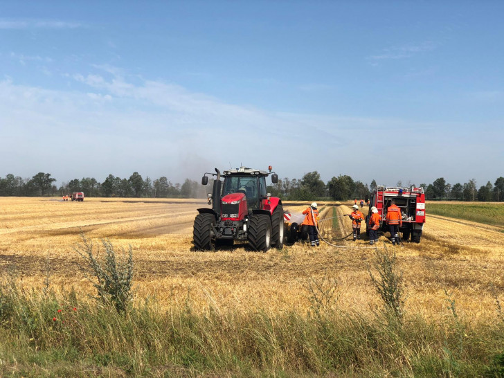 Das Tanklöschfahrzeug aus Müden löscht die Reste des Stoppelfeldbrandes (Hintergrund). Fotos: Timm Bußmann