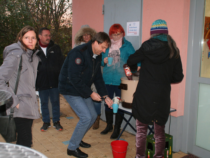 Bürgermeister Detlef Kaatz zapft sich den Glühwein selbst, die stellvertretende Ortsbürgermeisterin von Hemkenrode, Ute Baars, schaut gespannt zu. Foto: Diethelm Krause-Hotopp