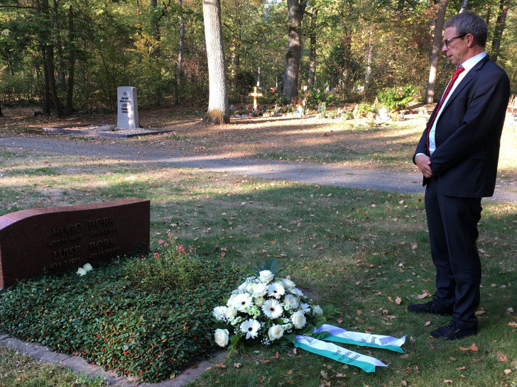 Oberbürgermeister Klaus Mohrs legt ein Blumengebinde auf dem Grab von Hugo Bork nieder. Foto: Stadt Wolfsburg