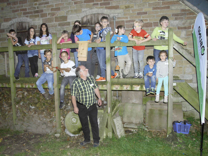 Thomas Keller und 15 Kinder mit Fledermauskasten und Fledermausattrappe vor der
Fledermaussuche mit den Detektoren. Foto: BUND