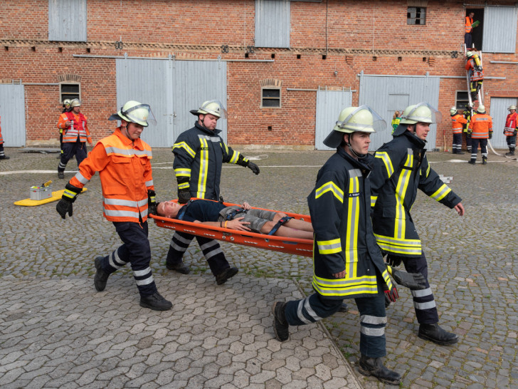 Eine verletzte Person wird abtransportiert während im Hintergrund eine weitere Person über eine Leiter gerettet wird. Fotos: Tanja Bischoff