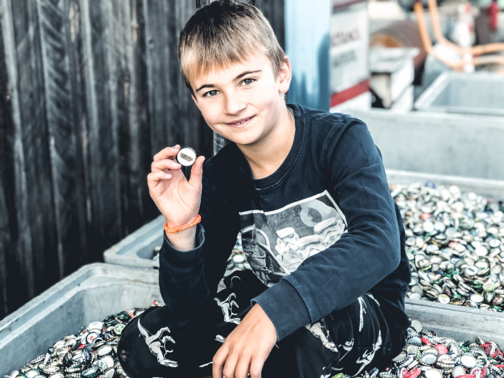 Der 9-jährige Sohn des Vereinsgründers Felix Busse  präsentiert die Masse an gesammelten Kronkorken. Foto: Lila Hoffnung – CED und Darmkrebshilfe e. V.
