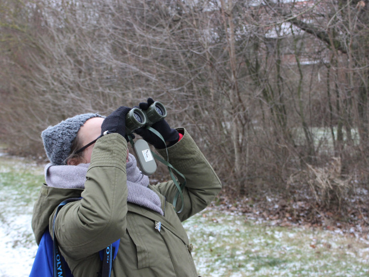 Eine Mitarbeiterin des NABU erfreut sich am Anblick eines Wintervogels. Foto: Alexander Panknin