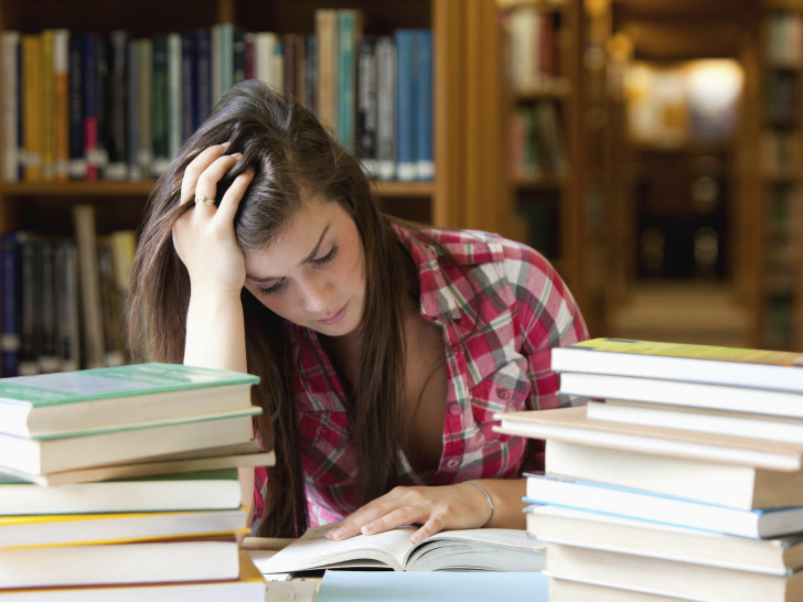 Junge Frau lernt in einer Bibliothek. Foto: Arbeitsagentur