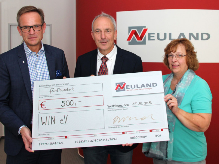 Hans-Dieter Brand übergibt die Spende an Joachim Harms und Rita Rummrich von WIN e.V. Foto: Neuland