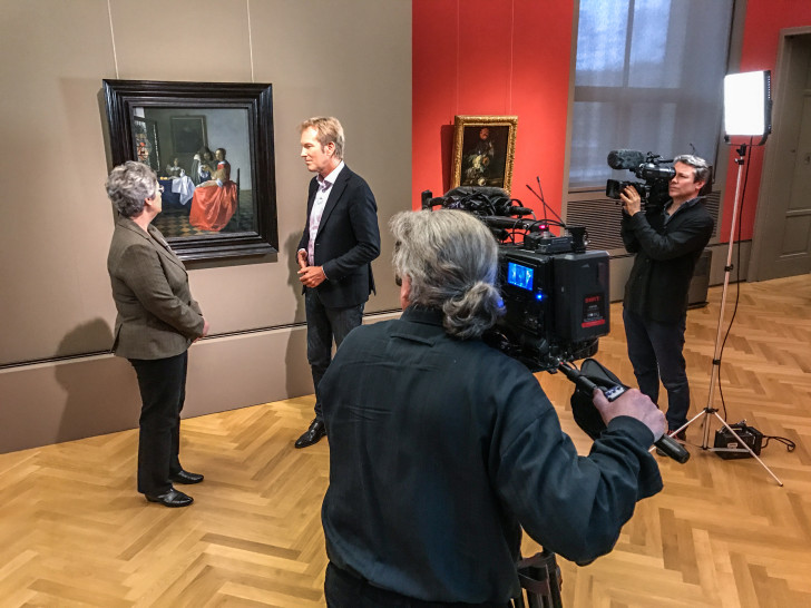 Das 3sat-Filmteam, Markus Brock und Dr. Silke Gatenbröcker, Leiterin der Gemäldegalerie des HAUM, vor dem Vermeer „Das Mädchen mit dem Weinglas“. Foto: C. Cordes, HAUM