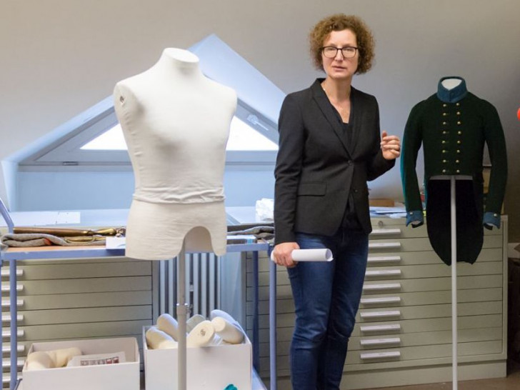 Museumsdirektorin Dr. Heike Pöppelmann präsentiert die restaurierte Uniform. Foto: A. Pröhle, BLM
