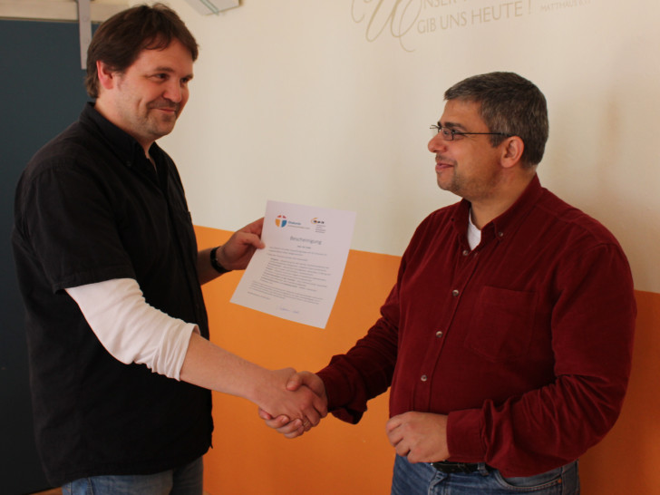 Sozialpädagoge und Gesprächsgruppenleiter Lars-P. Förstermann-Gössel überreicht einem der Gruppenteilnehmer die verdiente Bescheinigung. Foto: Christina Ecker