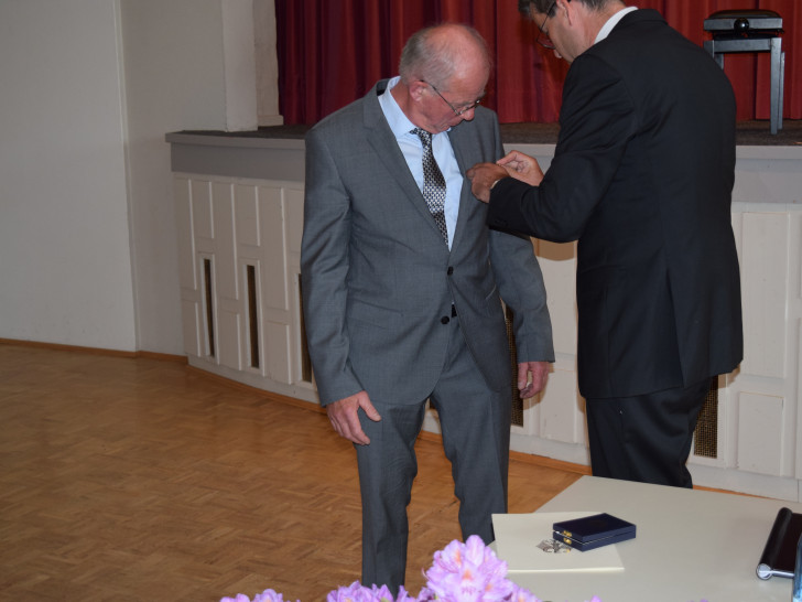 Dr. Oliver Junk steckt Heinrich Wilgenbus das Verdienstkreuz am Bande des Verdienstordens der Bundesrepublik Deutschland an. Foto: Stadt Goslar