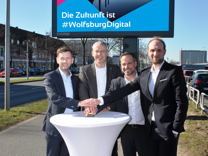 Dennis Weilmann, Kai-Uwe Hirschheide, Dirk Geßner und Jens Hofschröer nahmen die neuen, digitale Informationsflächen gemeinsam in Betrieb (v. li.). Foto: Stadt Wolfsburg