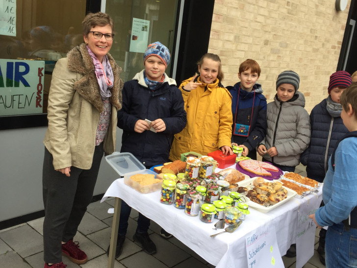 Lehrerin Jutta Schnippe mit den Schülern beim Kuchenverkauf. Foto: GiS