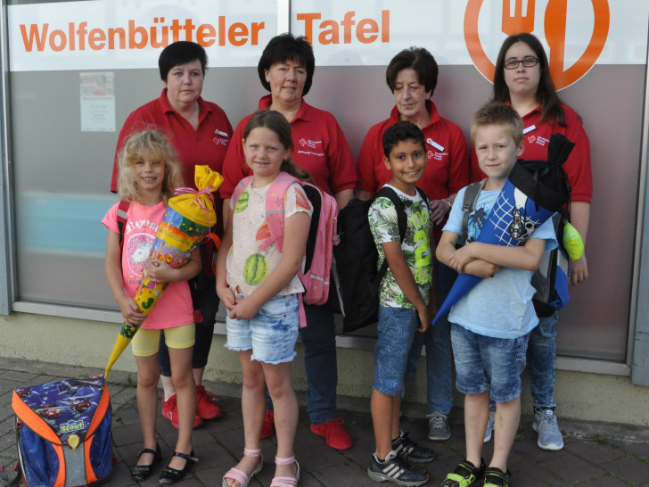 Die Tafelmitarbeiterinnen Susanne Smyczek (hinten von links), Juliane Liersch, Ursula Pflug und Denise Smyczek überreichen den ersten vier Kindern ihre neuen Schulutensilien. Foto: DRK