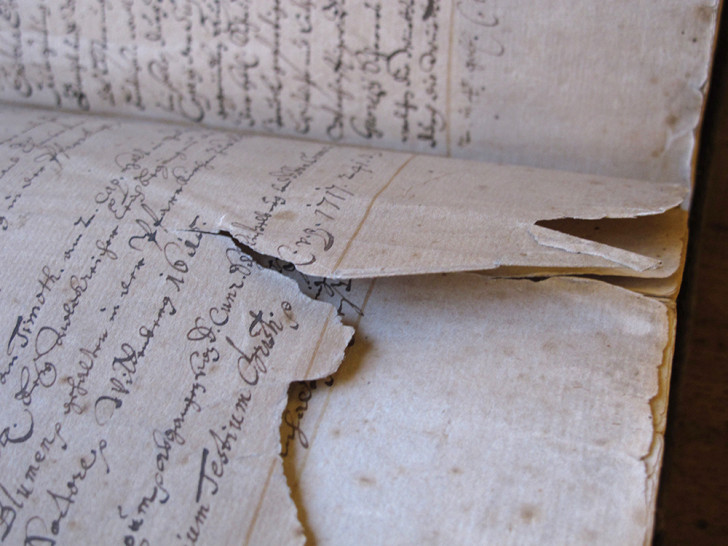 In der Herzog August Bibliothek zeigt die restaurierten Bände. Hier ein Buch mit einer von über 7000 Buchseiten, die durch jahrhundertelange Benutzung stark beschädigt sind. Foto: HAB
