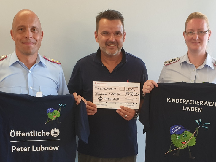 Stellvertretend für die Kinderfeuerwehr Linden nahmen Ortsbrandmeister Marco Dickhut (li.) und Kinderfeuerwehrwartin Meike Beinert die Geschenke von Peter Lubnow entgegen. Foto: Stadt Wolfenbüttel