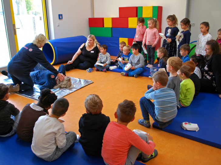 Johanniter-Trainerin Susanne Felka zeigt den Kindern, wie die stabile Seitenlage geht. Fotos: Natalia Shapovalova/Johanniter