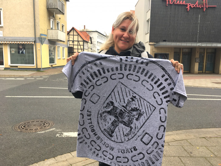 Cathy präsentiert ihr Andenken: Ein bedrucktes T-Shirt mit dem Gully-Deckel-Motiv des Wolfenbütteler Wappens. Fotos: Nick Wenkel